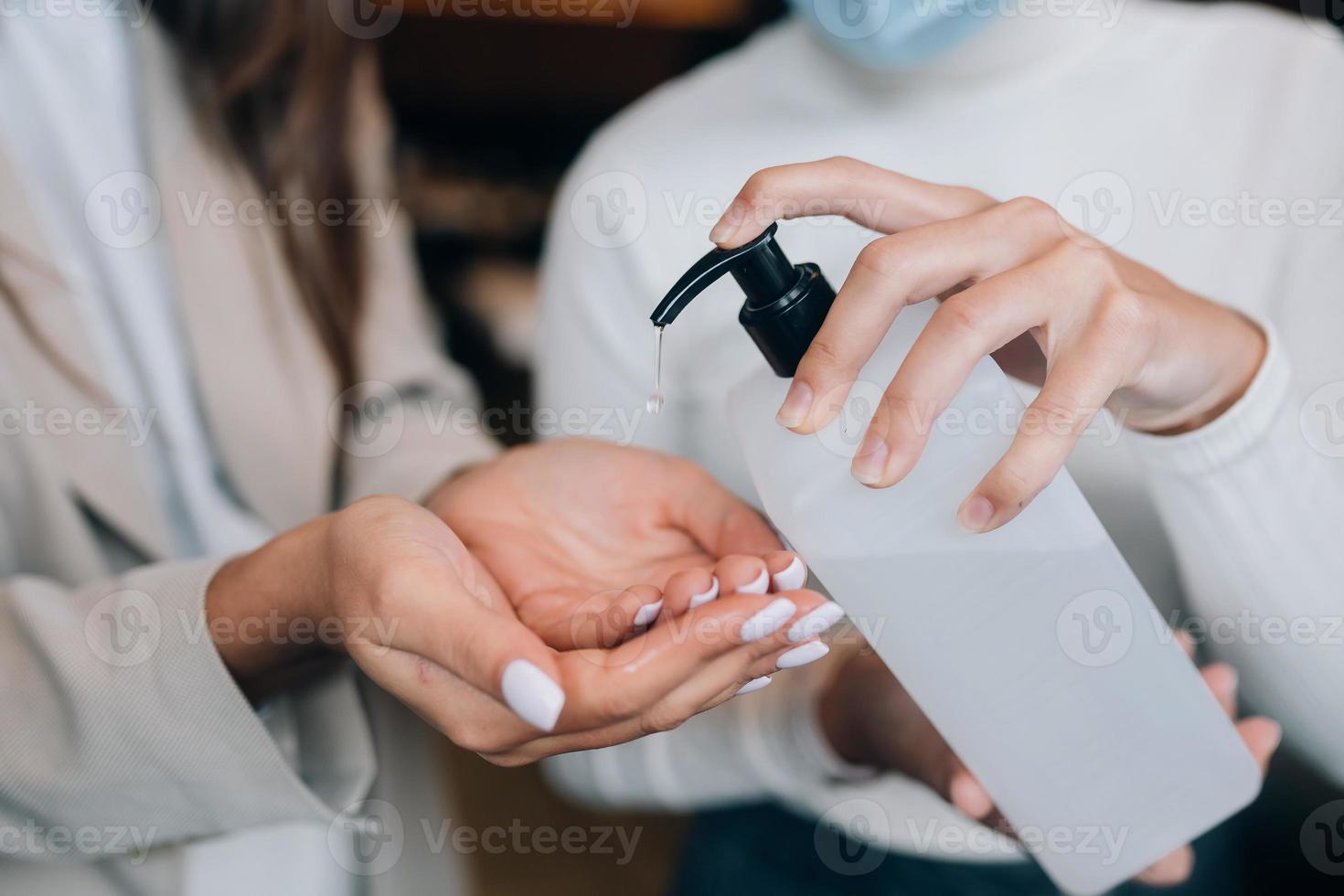 vrouw handen toepassen antibacteriële vloeistof zeep dichtbij omhoog. foto