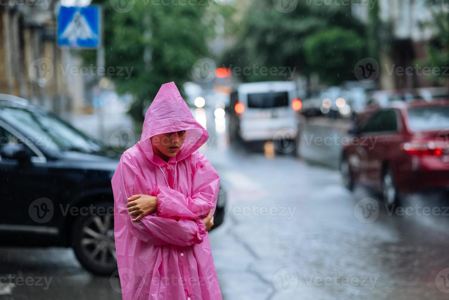 verdrietig vrouw in een regenjas Aan de straat in de regen foto