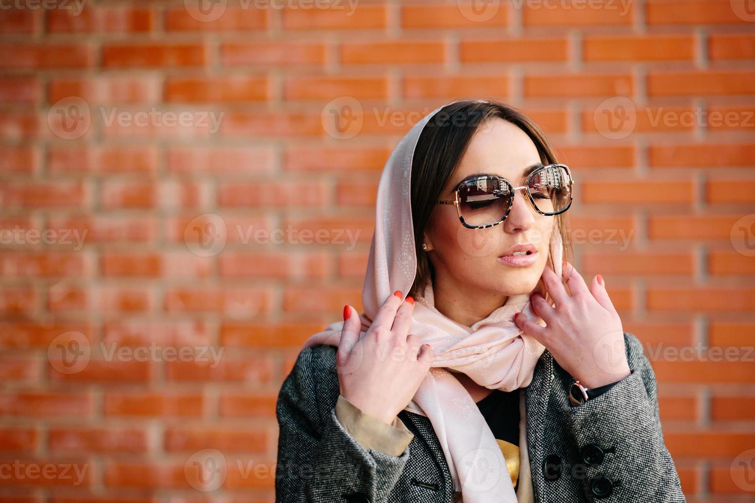 meisje poseren Aan een achtergrond van rood steen muur foto