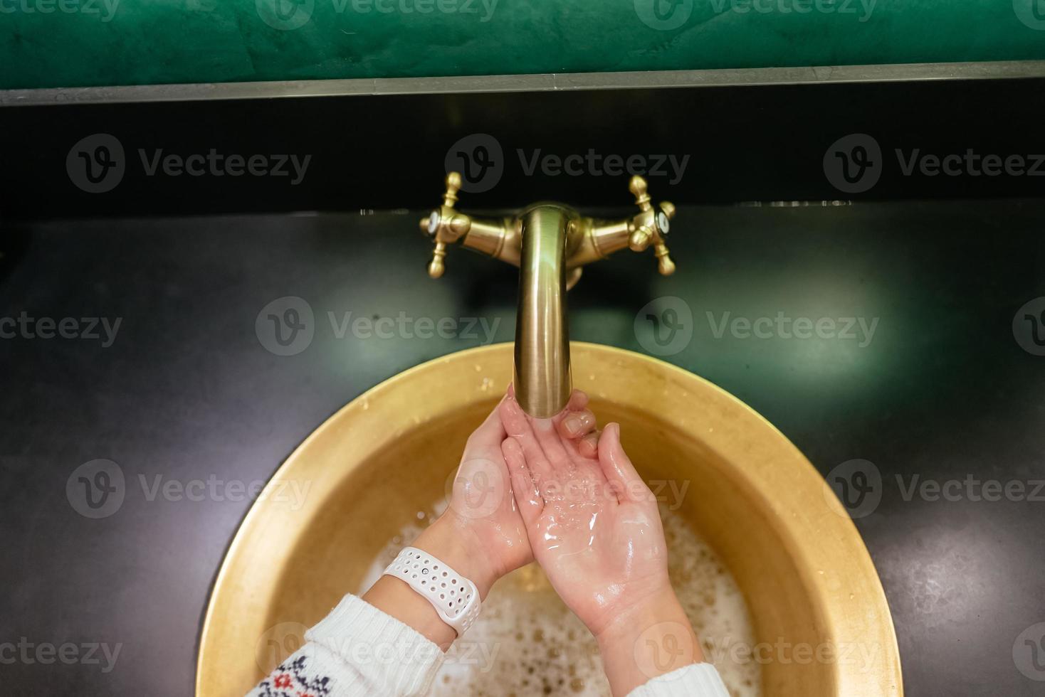 dichtbij omhoog foto van vrouw wast haar handen met zeep en water.