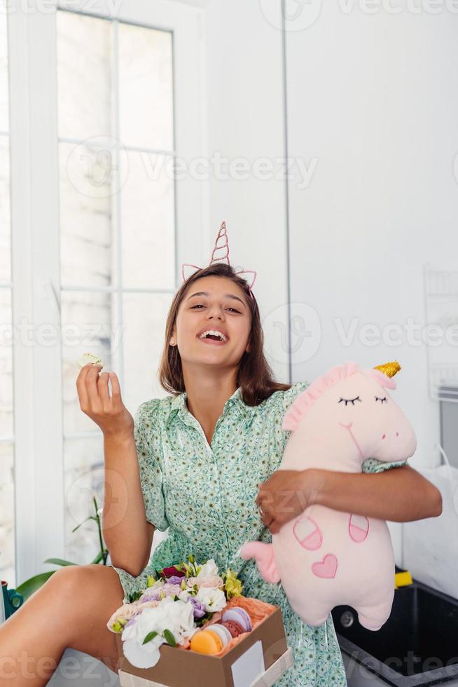 jong mooi vrouw aan het eten taart in modern keuken. foto