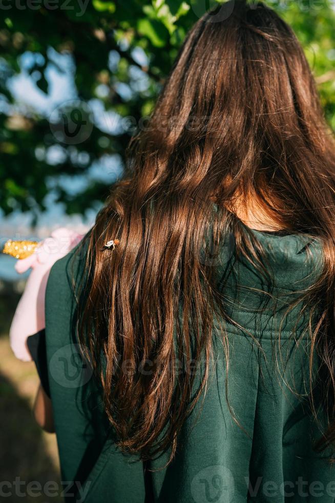 jong meisje met lang bruin haar, terug visie foto