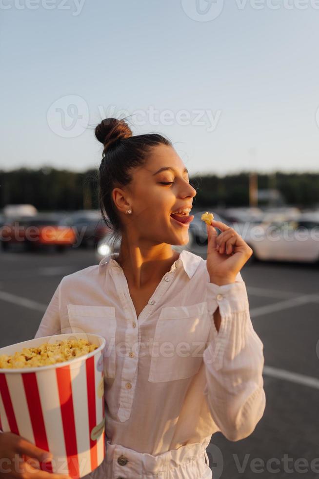 jong schattig vrouw Holding popcorn in een boodschappen doen winkelcentrum parkeren veel foto