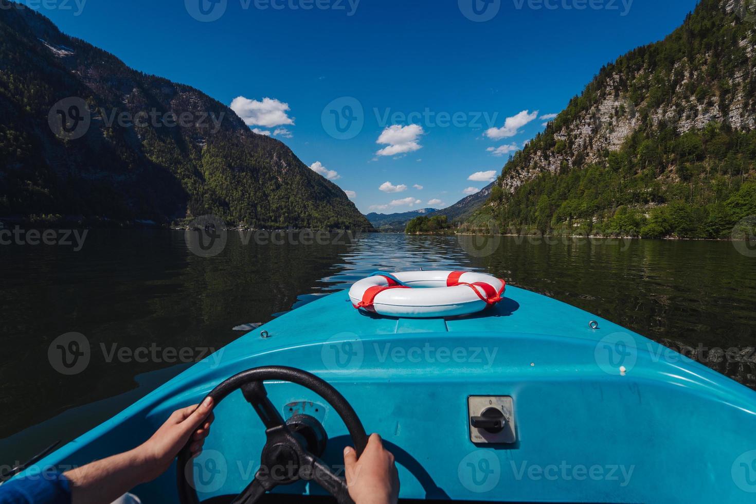 knap jong vent controles een motorboot Aan een berg meer foto