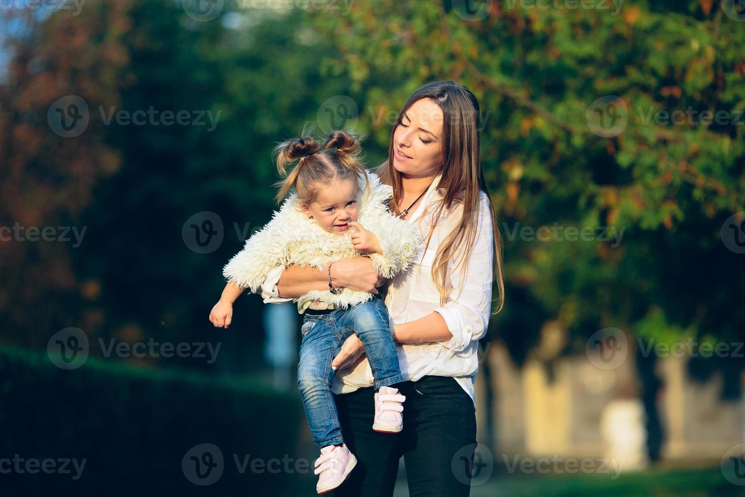 moeder en weinig dochter in een park foto