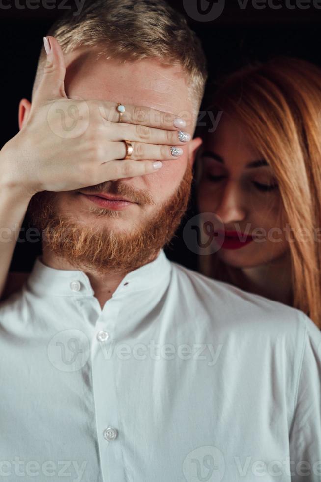 dichtbij omhoog van vrouw aan het bedekken vriendjes ogen met handen. foto