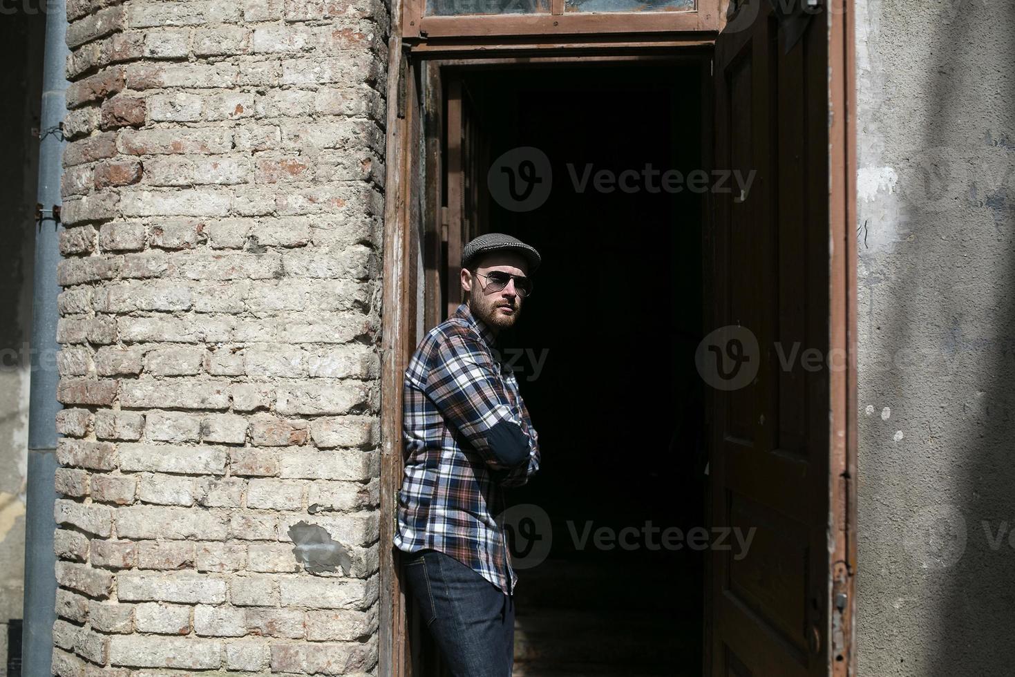 de man in de authentieke laarzen en zelfkantjeans op een achtergrond van de oude stad foto