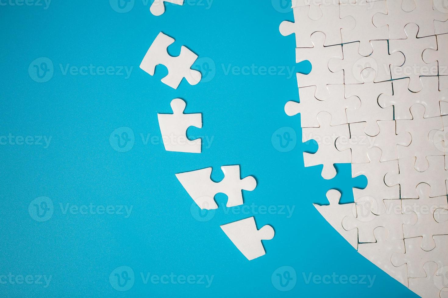 witte deel van puzzelstukjes op blauwe achtergrond. concepten van probleemoplossing, zakelijk succes, teamwork, teamplaying puzzelspel onvolledig, textuurfoto met kopieerruimte voor tekst foto
