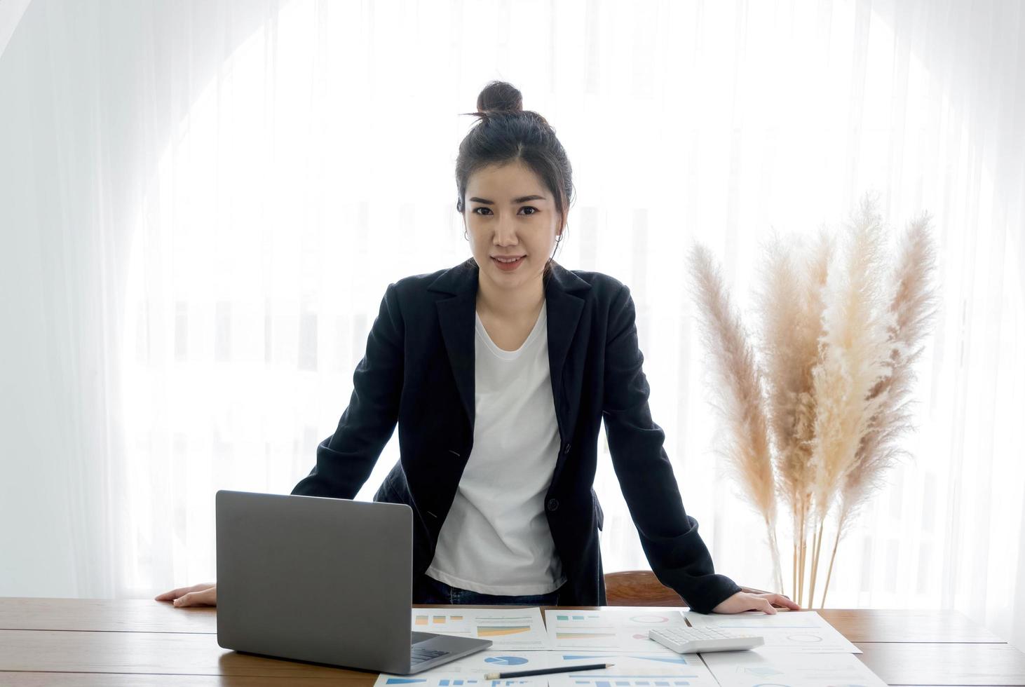 charmant Aziatisch zakenvrouw met een glimlach staand slim Bij de kantoor op zoek Bij de camera. foto