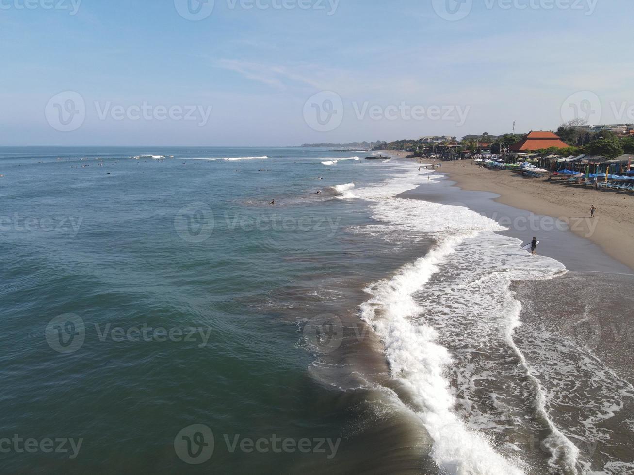 antenne visie van mensen surfing Aan golven met surfplanken wanneer vakantie in Bali, Indonesië foto