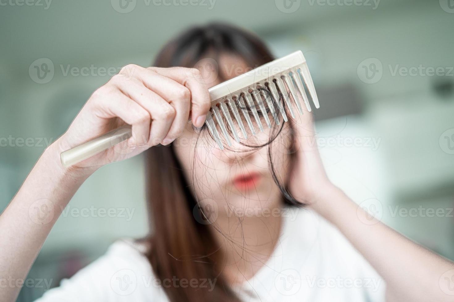 aziatische vrouw heeft een probleem met lang haarverlies, hecht zich aan de kamborstel. foto