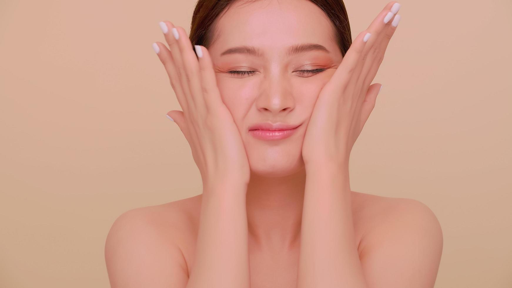 een jong vrouw masseren haar gezicht. portret van aantrekkelijk meisje met zacht bedenken en perfect mooi huid. foto