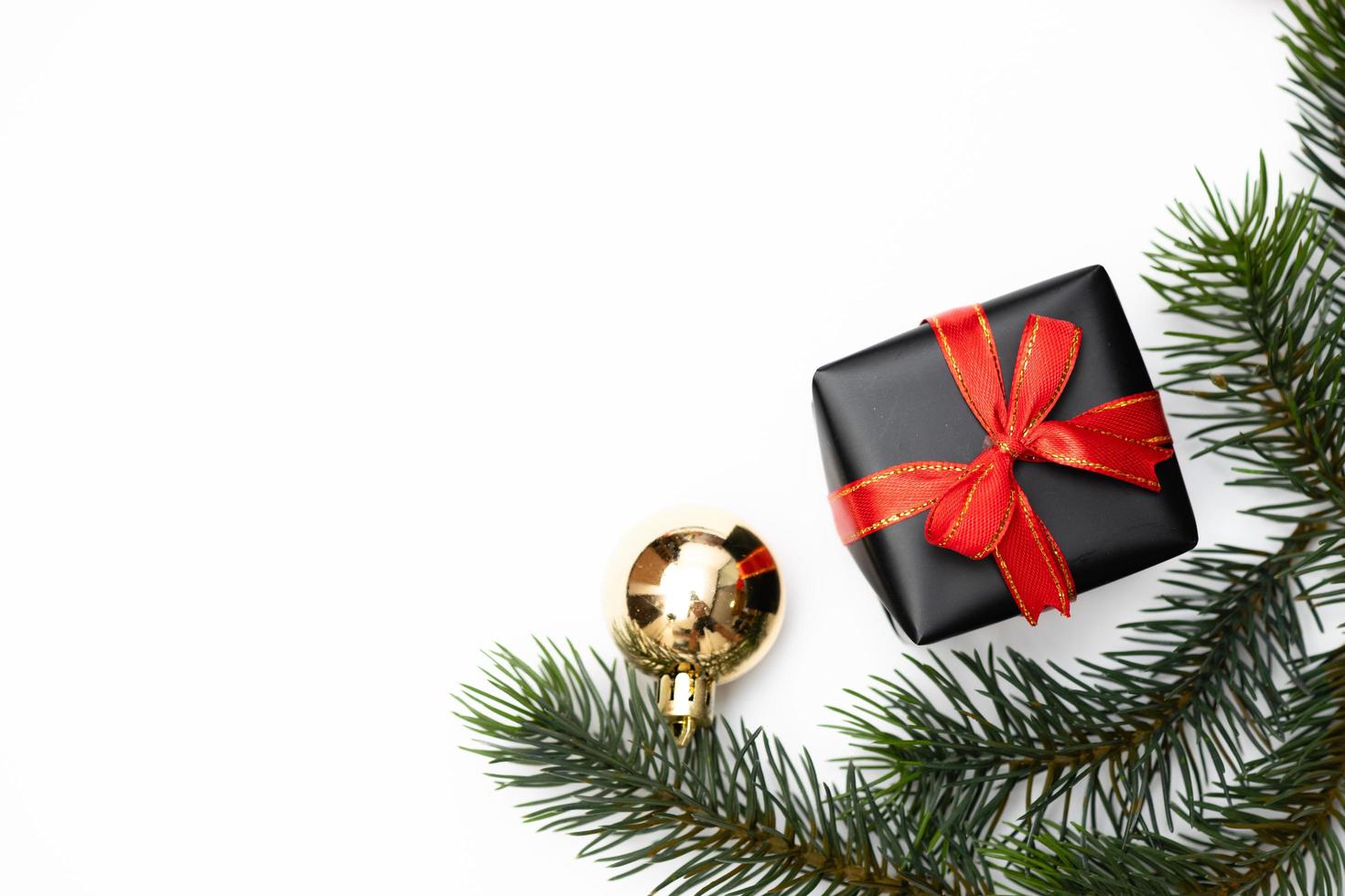 top visie van Kerstmis geschenk doos rood ballen met net takken, pijnboom kegels, rood bessen en klok Aan wit achtergrond. foto