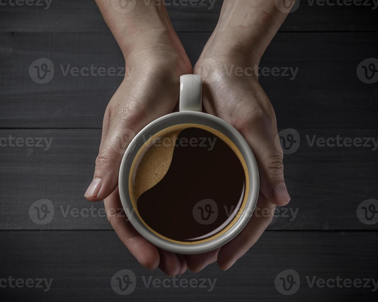 heet koffie kop in handen met koffie bonen Aan de houten tafel foto