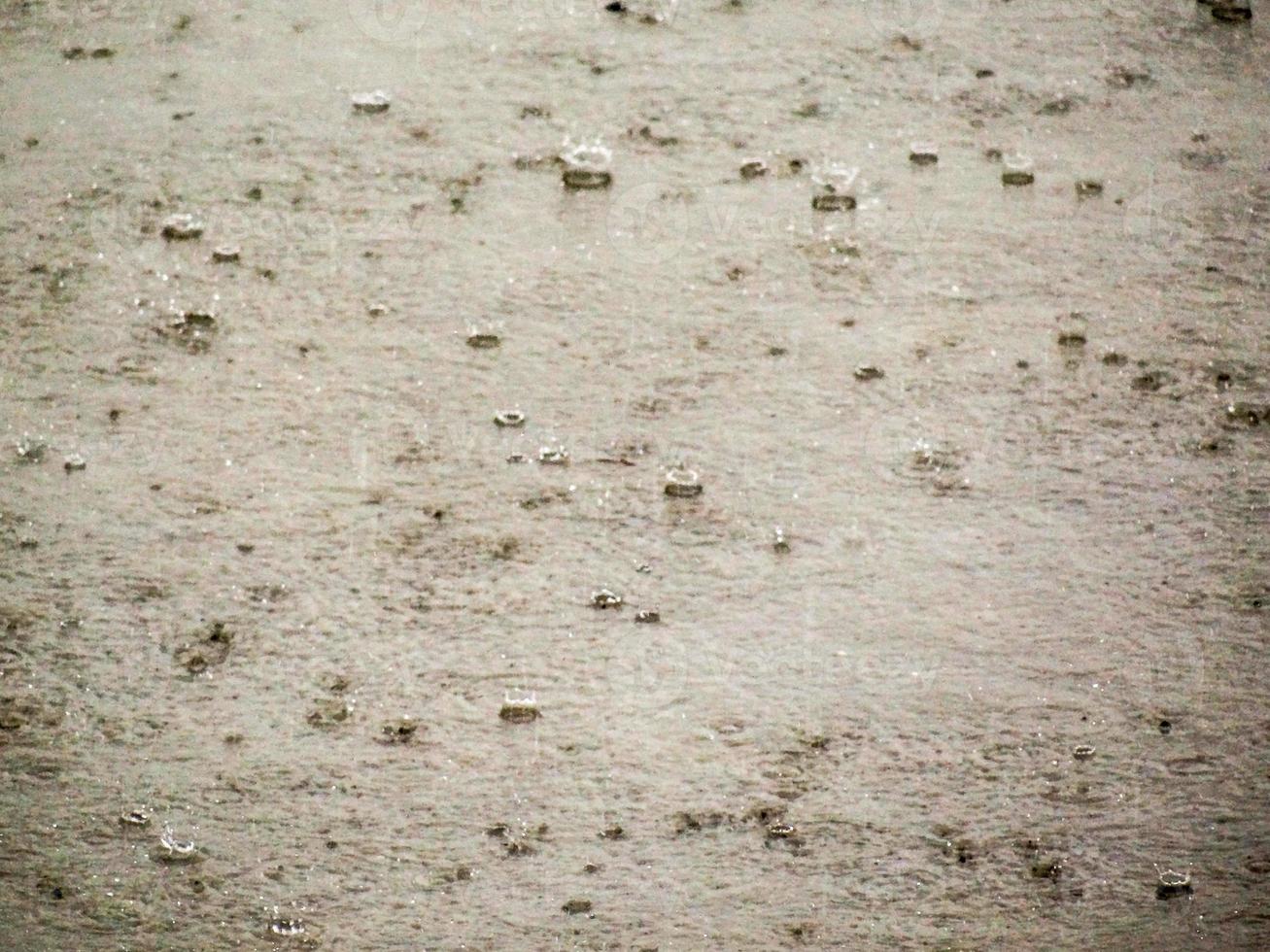 druppels van regen tegen de beton foto