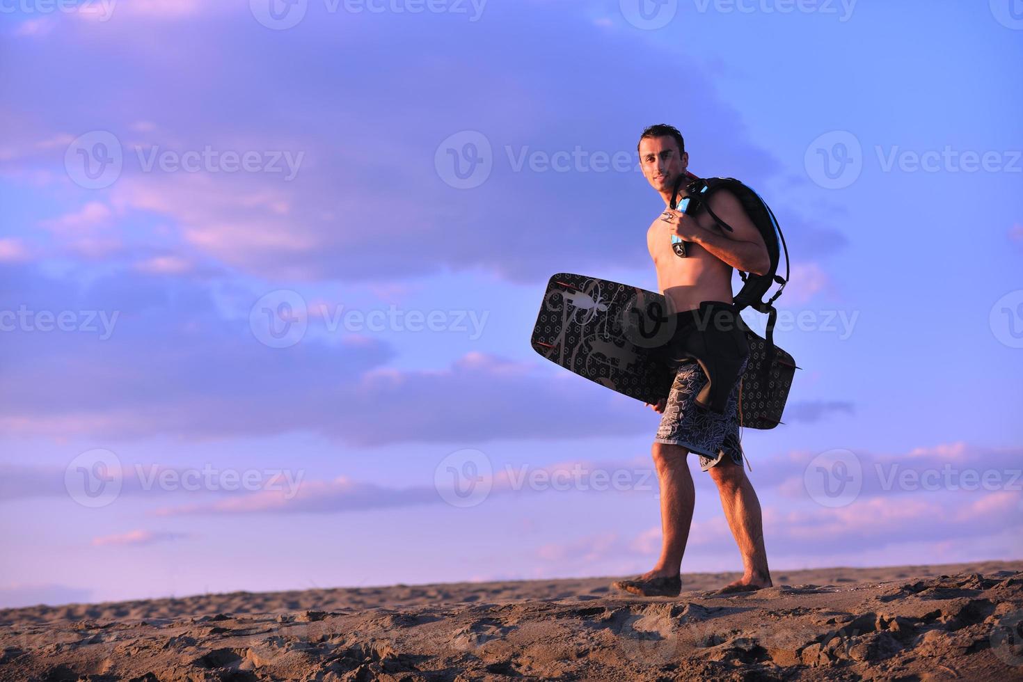 portret van een jong kitsurfen Mens Bij strand Aan zonsondergang foto