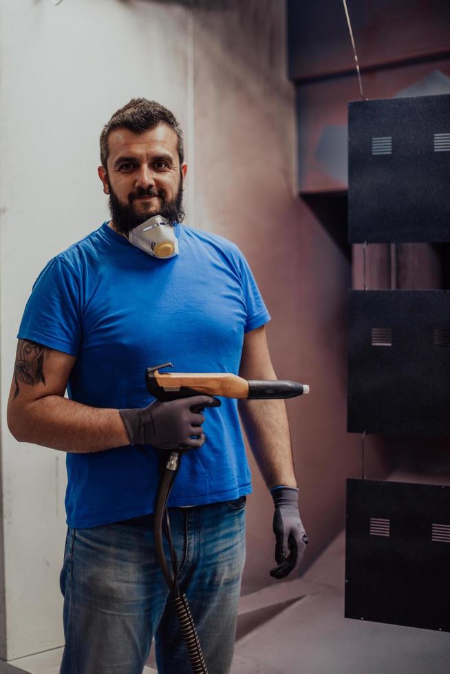 de schilder schildert het ijzeren element. industriële verf onderdelen. metalen ontwerpen foto