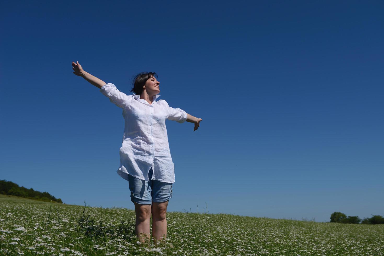 jonge gelukkige vrouw in groen veld foto