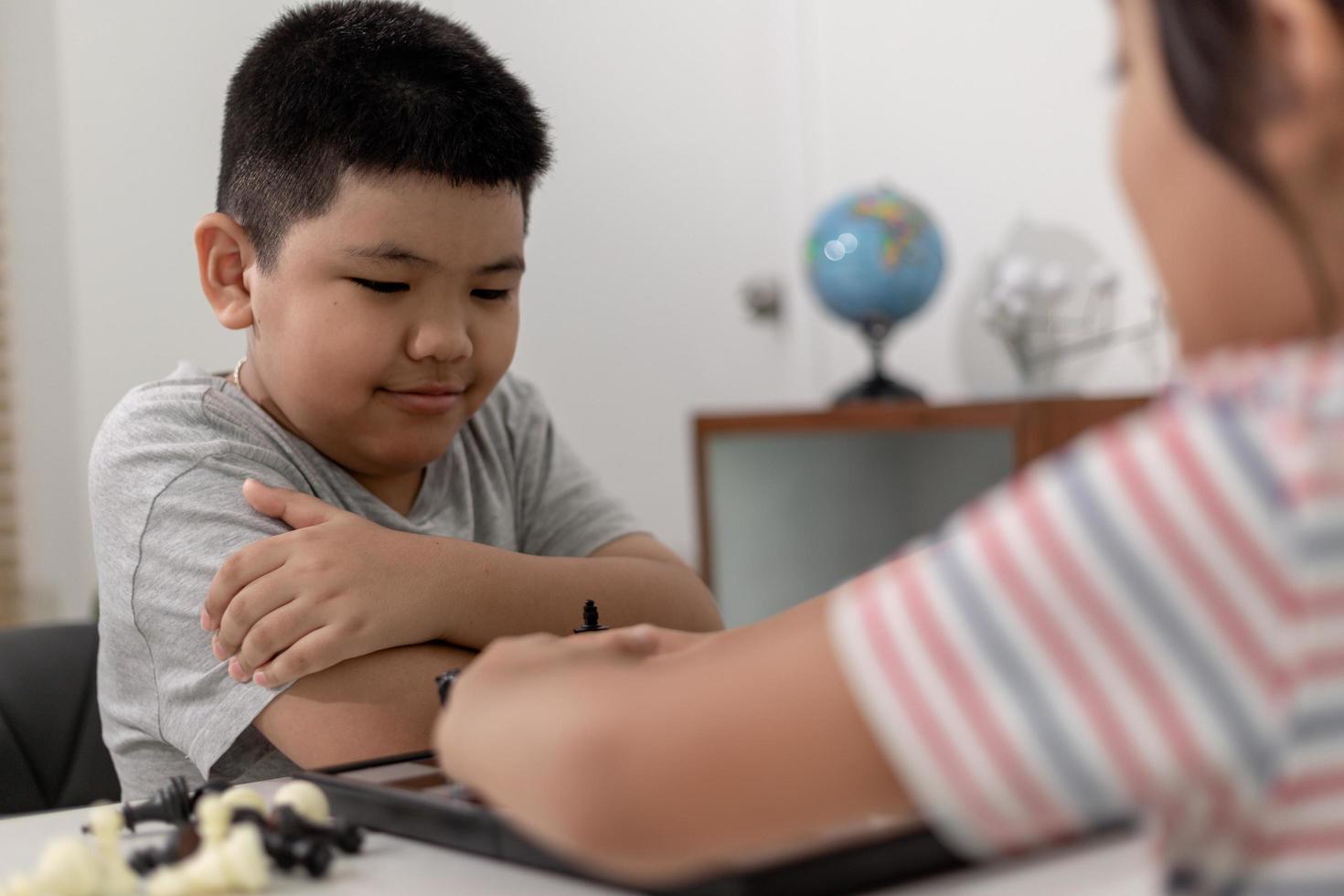 kleine jongen en meisje spelen thuis schaken. kinderen schaken foto