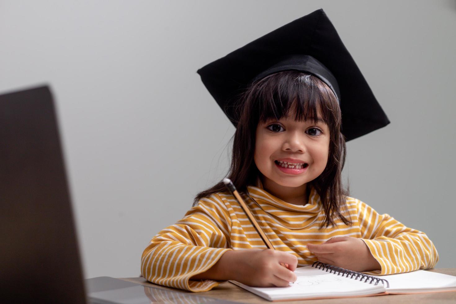 gelukkig Aziatisch school- kind afstuderen in diploma uitreiking pet foto