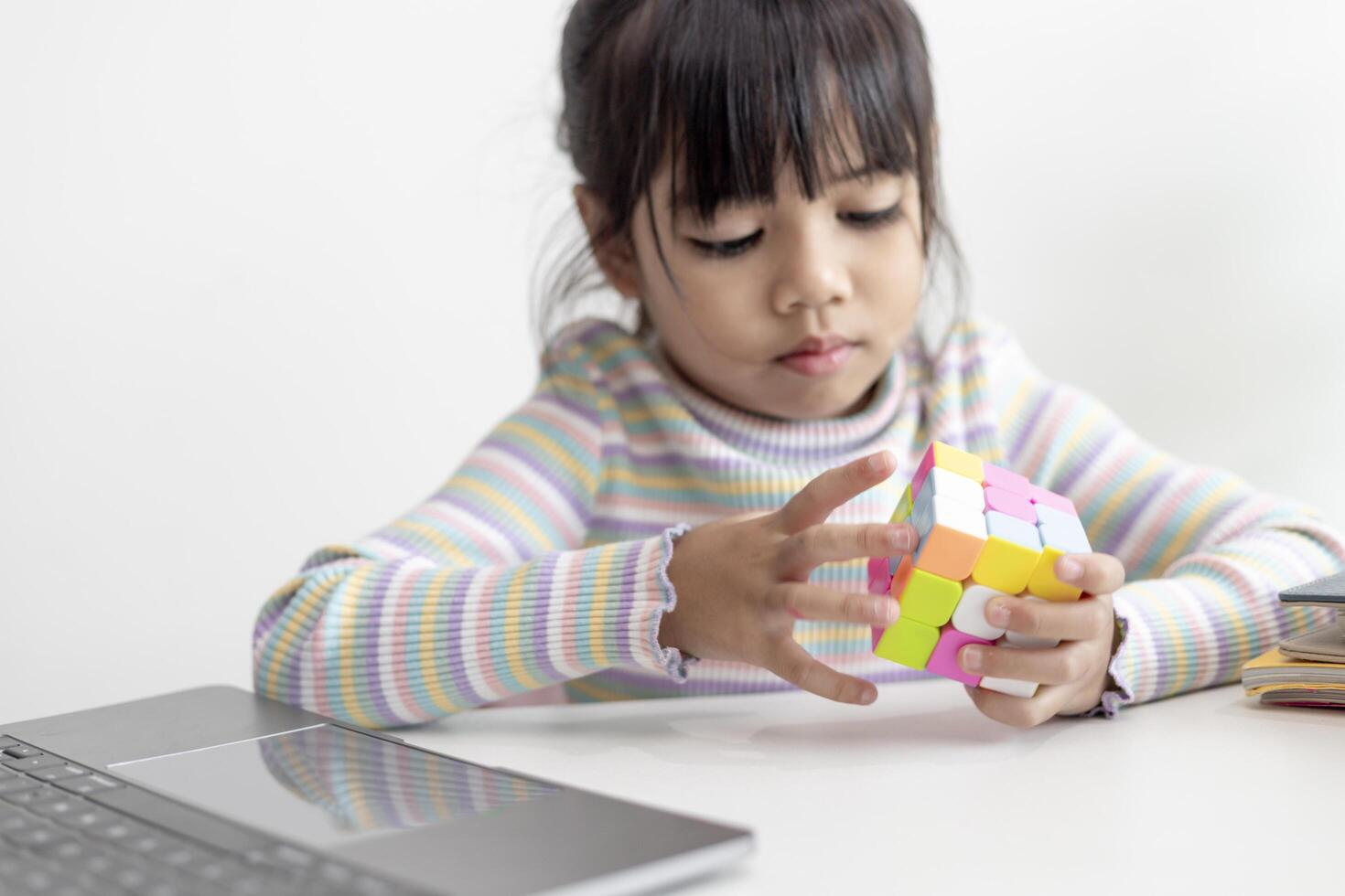 Nakhon ratchasima Thailand juli 14 2022 Aziatisch weinig schattig meisje Holding rubik's kubus in haar handen. rubik's kubus is een spel dat neemt toe de intelligentie- van kinderen. foto