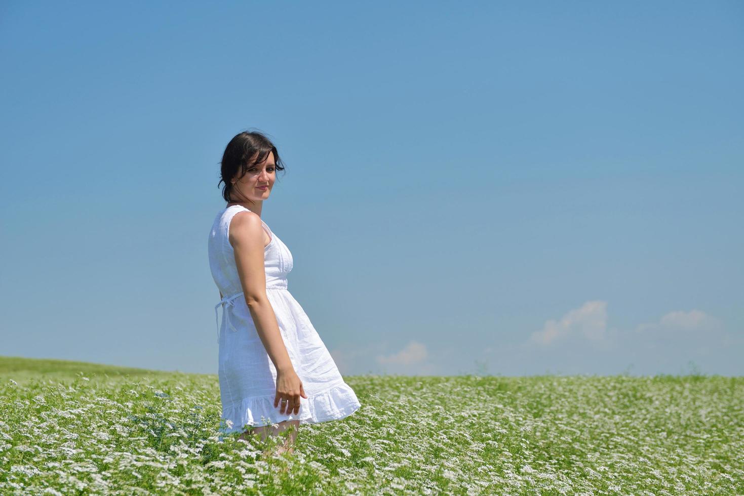 jonge gelukkige vrouw in groen veld foto