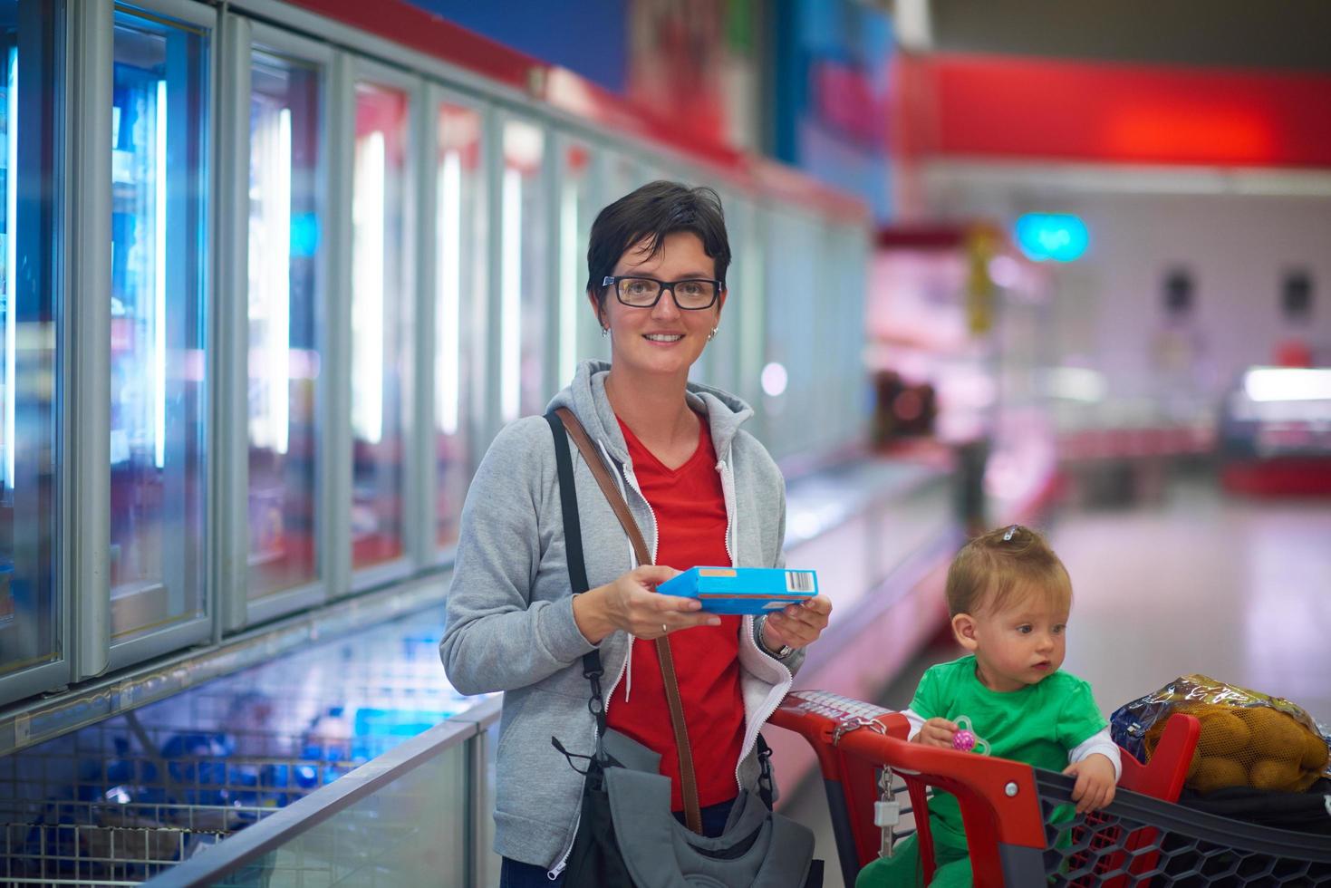 moeder met baby in boodschappen doen foto