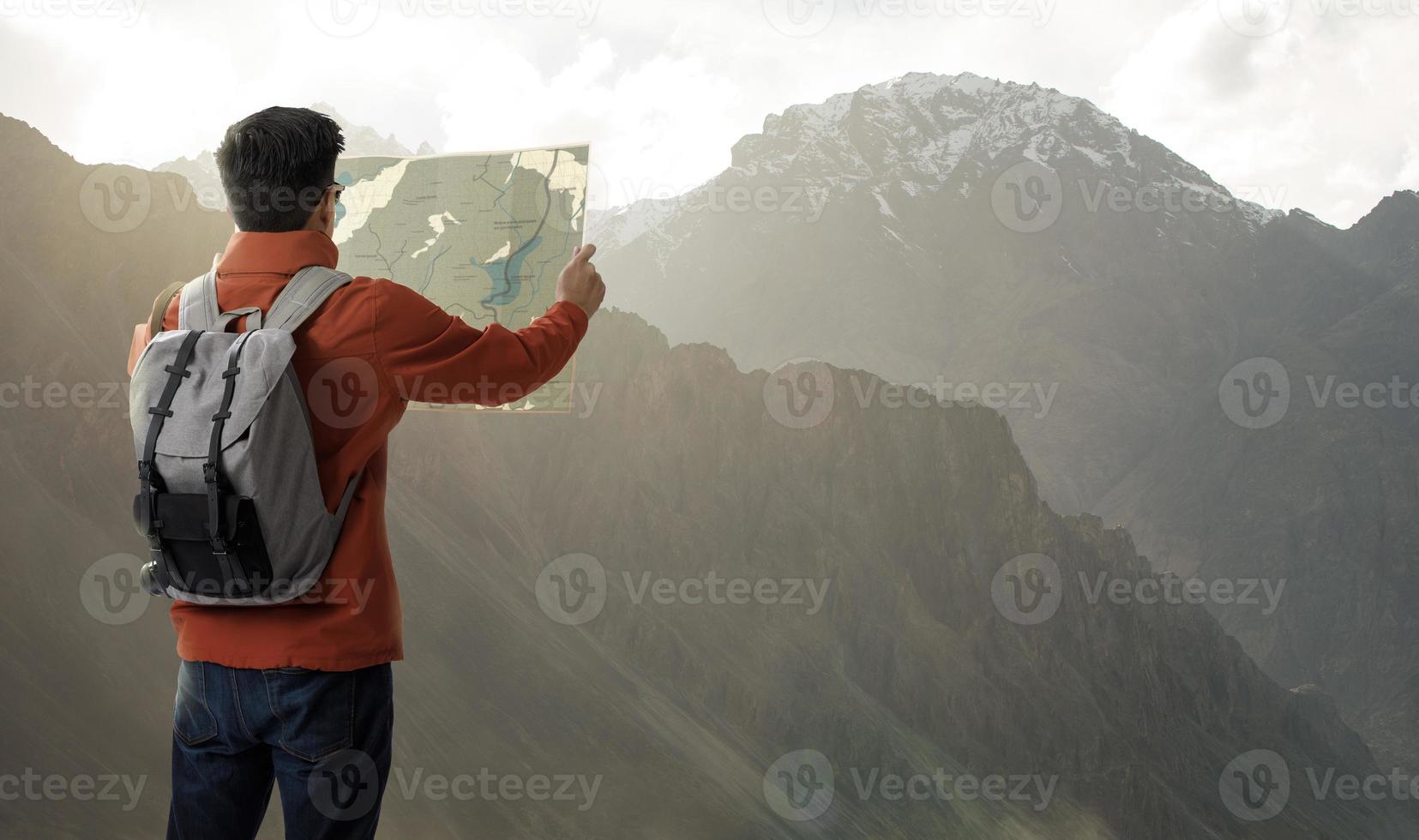 een jong reiziger Mens Aan de top van berg met rugzak en kijken zoeken richting Aan plaats kaart, avontuur en reizen in de concept, op reis tour in Azië leh ladakh, india foto