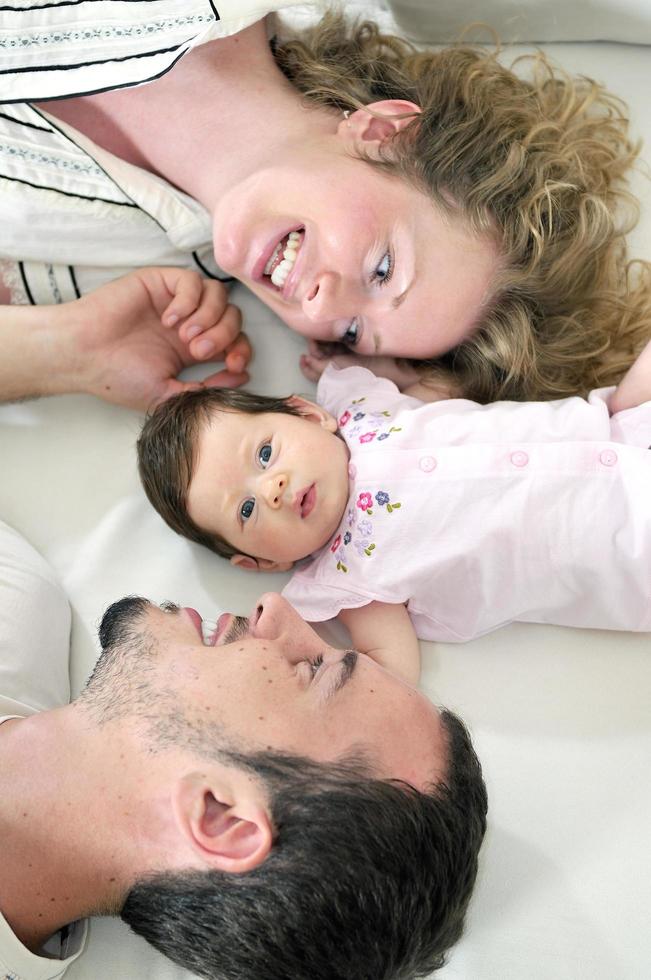 binnen- portret met gelukkig jong familie en schattig weinig babe foto