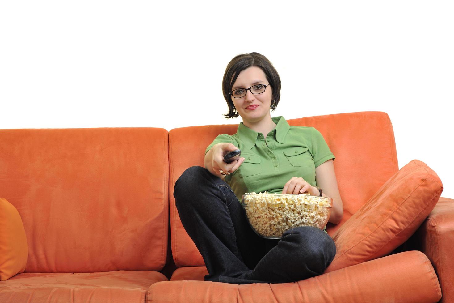 jong vrouw eten popcorn en aan het kijken TV foto