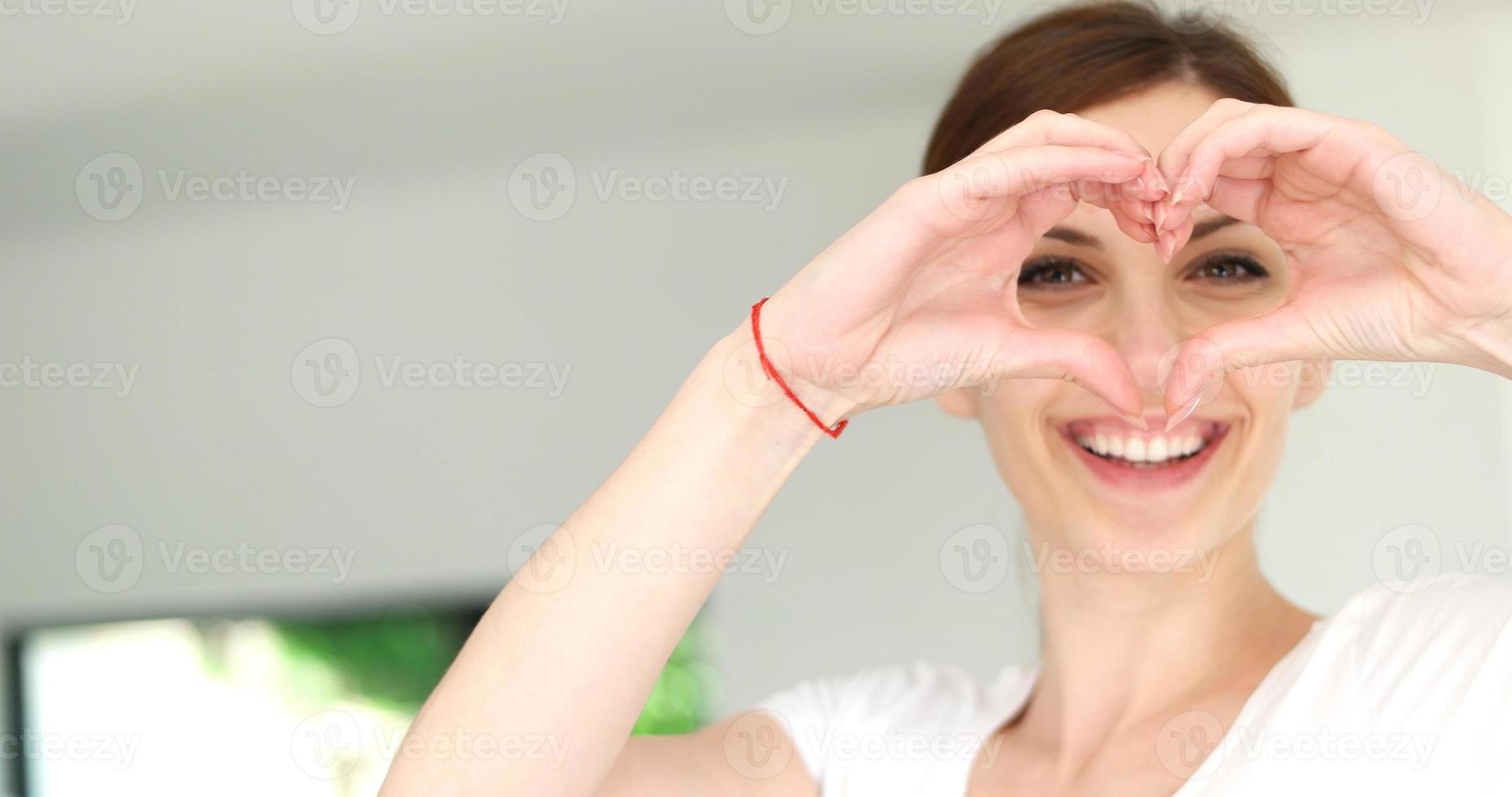 handgemaakt hart teken door jong vrouw, huis foto