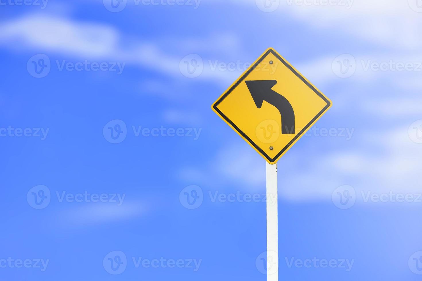 verkeer teken links u-bocht teken Aan cement pool naast de landelijk weg met wit bewolkt blauwe lucht achtergrond kopiëren ruimte foto