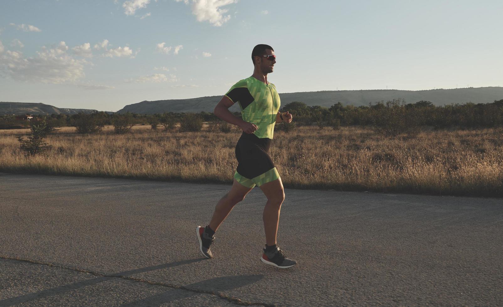 triatlonatleet die op ochtendtraining loopt foto