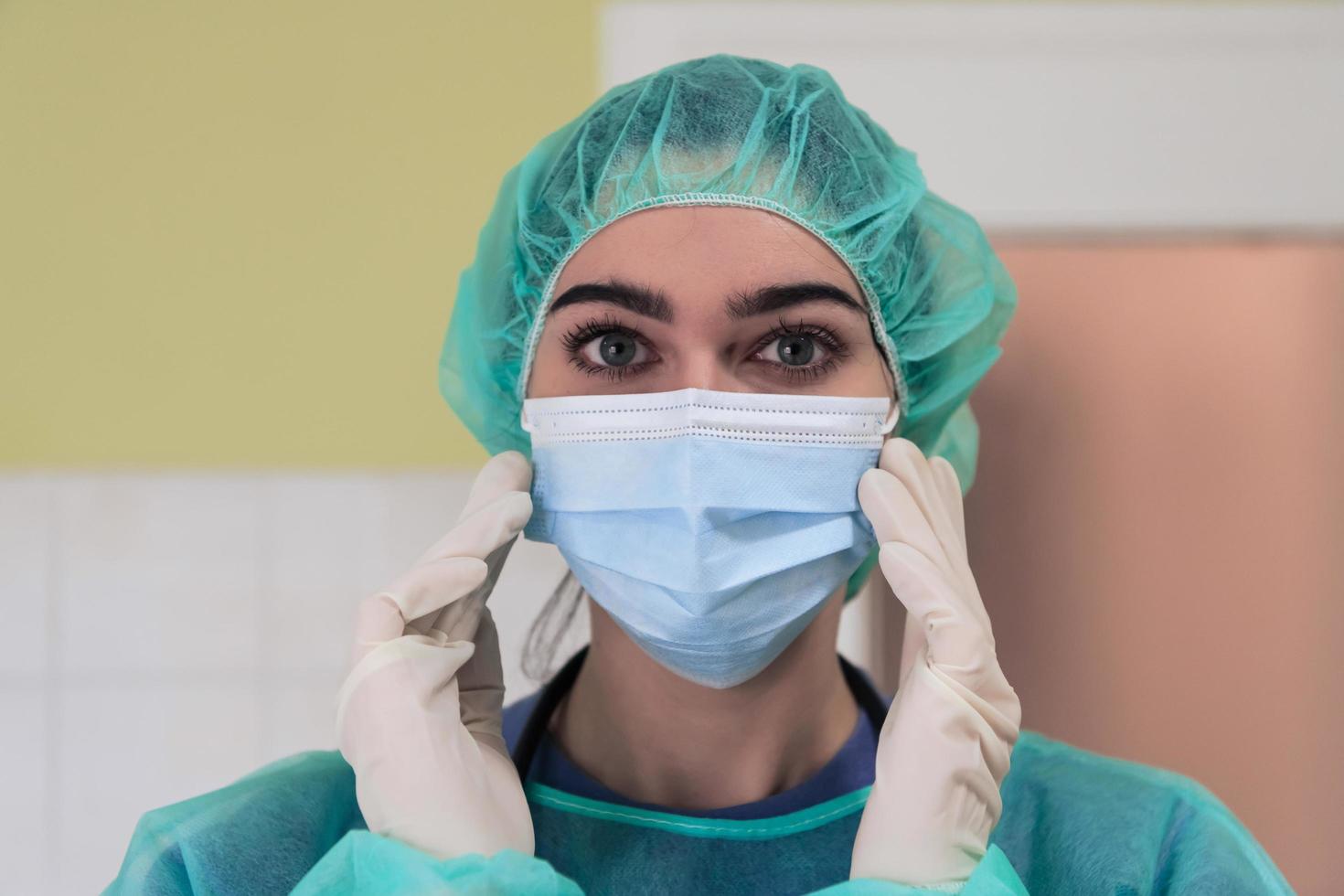 de vrouw dier chirurg of dierenarts zet Aan een medisch gezicht masker. dokter is voorbereidingen treffen voor chirurgie in de operatie kamer. geneeskunde en gezondheidszorg foto