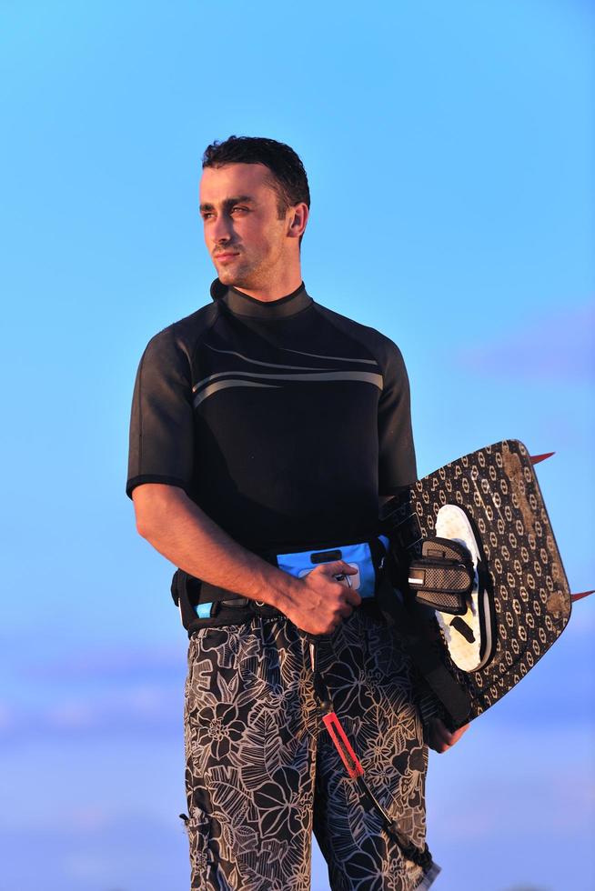 portret van een jong kitsurfen Mens Bij strand Aan zonsondergang foto