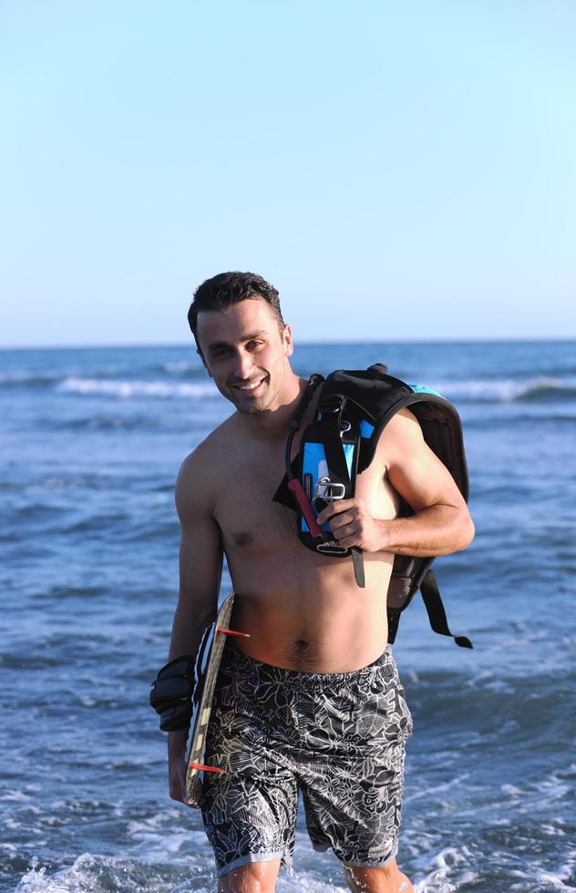 portret van een jong kitsurfen Mens Bij strand Aan zonsondergang foto