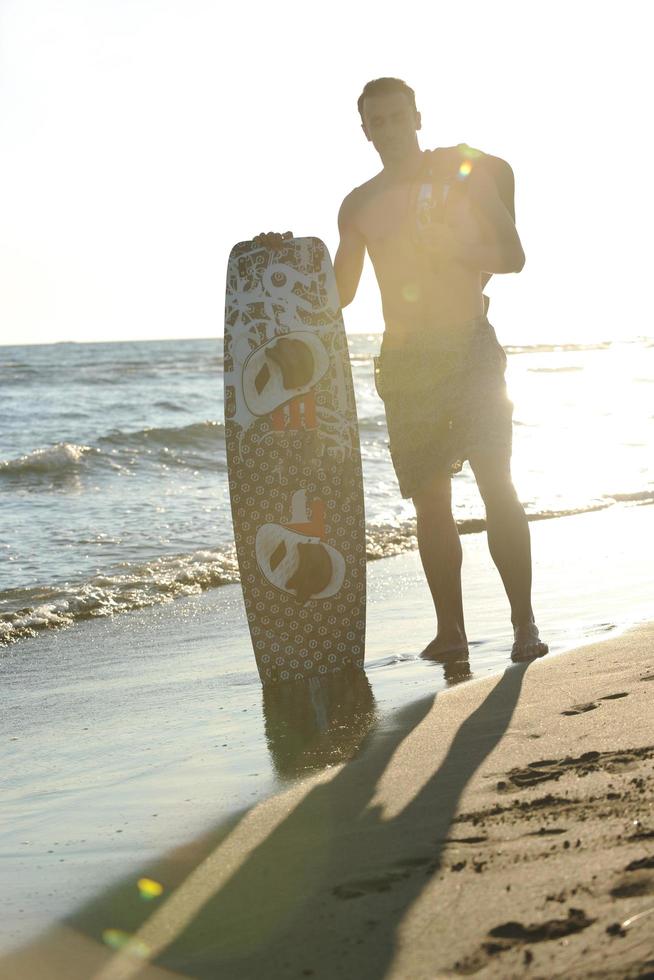 portret van een jong kitsurfen Mens Bij strand Aan zonsondergang foto