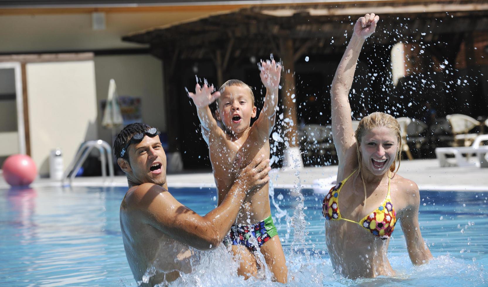 gelukkig jong familie hebben pret Aan zwemmen zwembad foto