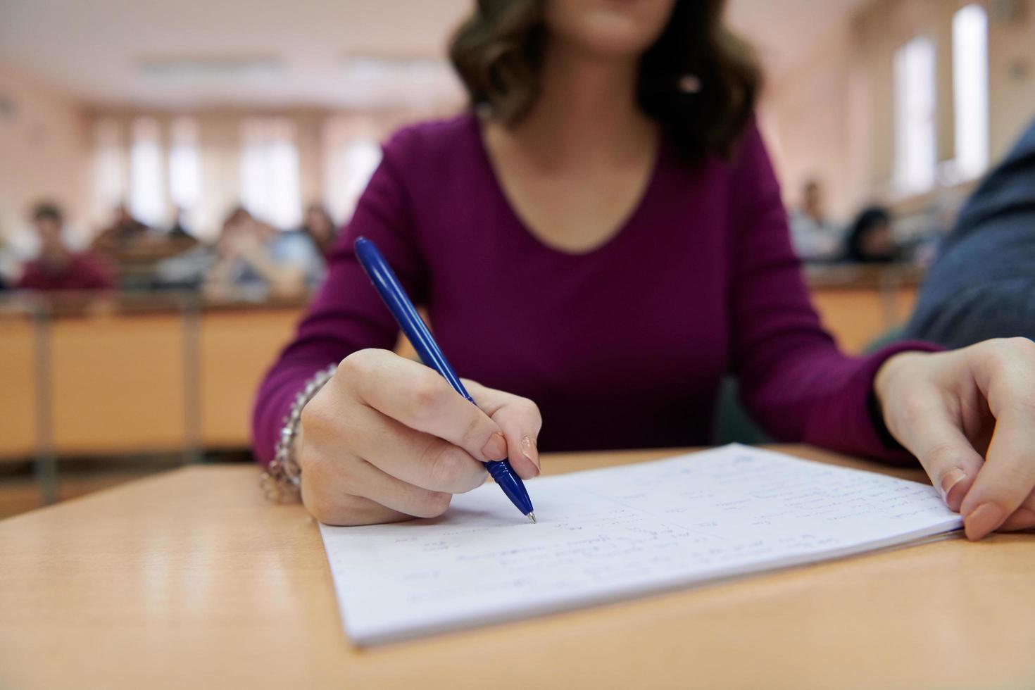 famale leerling gebruik makend van pen en notitieboekje foto