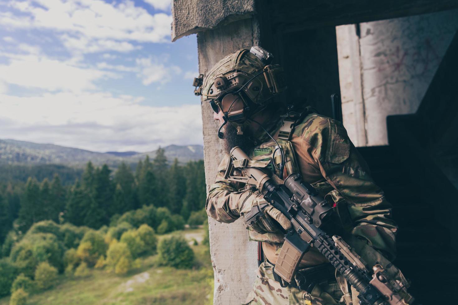 een gebaard soldaat in uniform van speciaal krachten in een gevaarlijk leger actie in een gevaarlijk vijand Oppervlakte. selectief focus foto