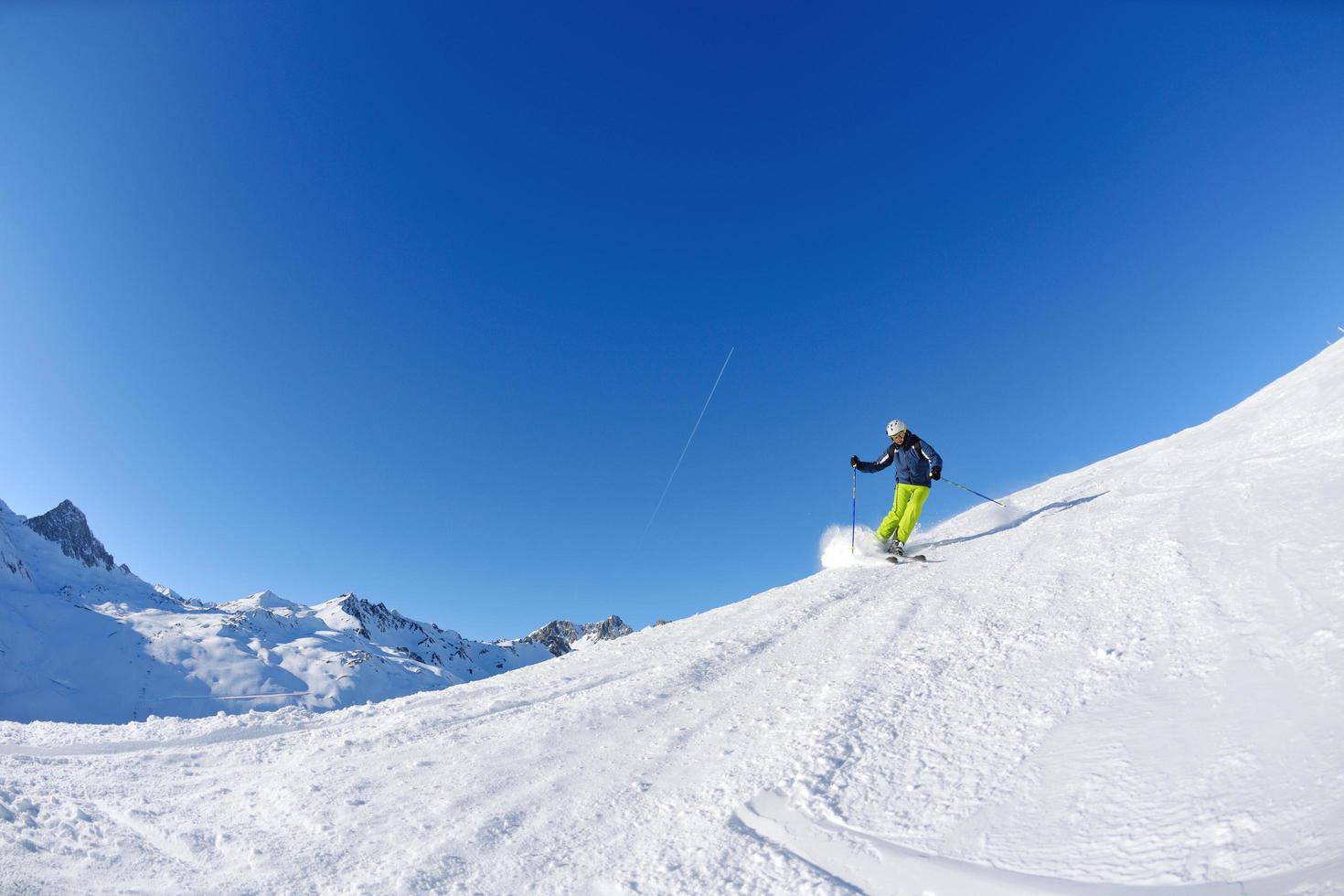 skiën op verse sneeuw in het winterseizoen op een mooie zonnige dag foto