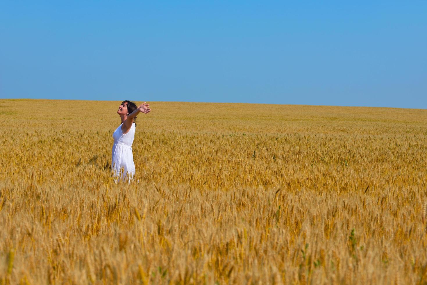 jonge vrouw in tarweveld in de zomer foto