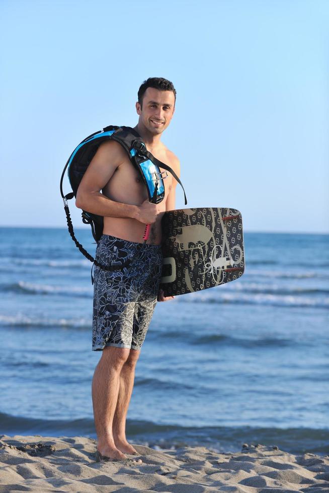 portret van een jong kitsurfen Mens Bij strand Aan zonsondergang foto