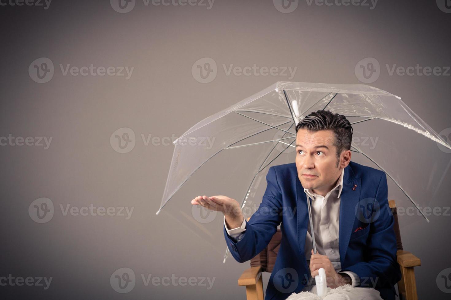 zakenman schuilplaats onder een paraplu en controle als het regent. kopiëren ruimte. foto