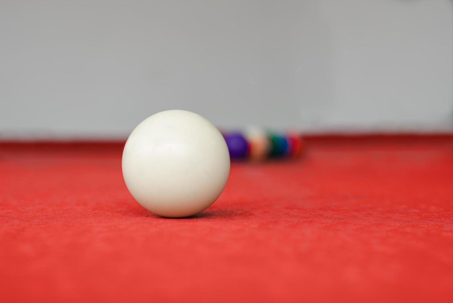 wit snooker bal Aan rood snooker tafel foto