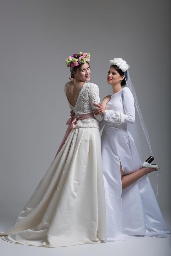 portret van twee mooi jong bruid in bruiloft jurken foto