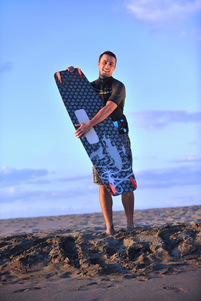 portret van een jong kitsurfen Mens Bij strand Aan zonsondergang foto