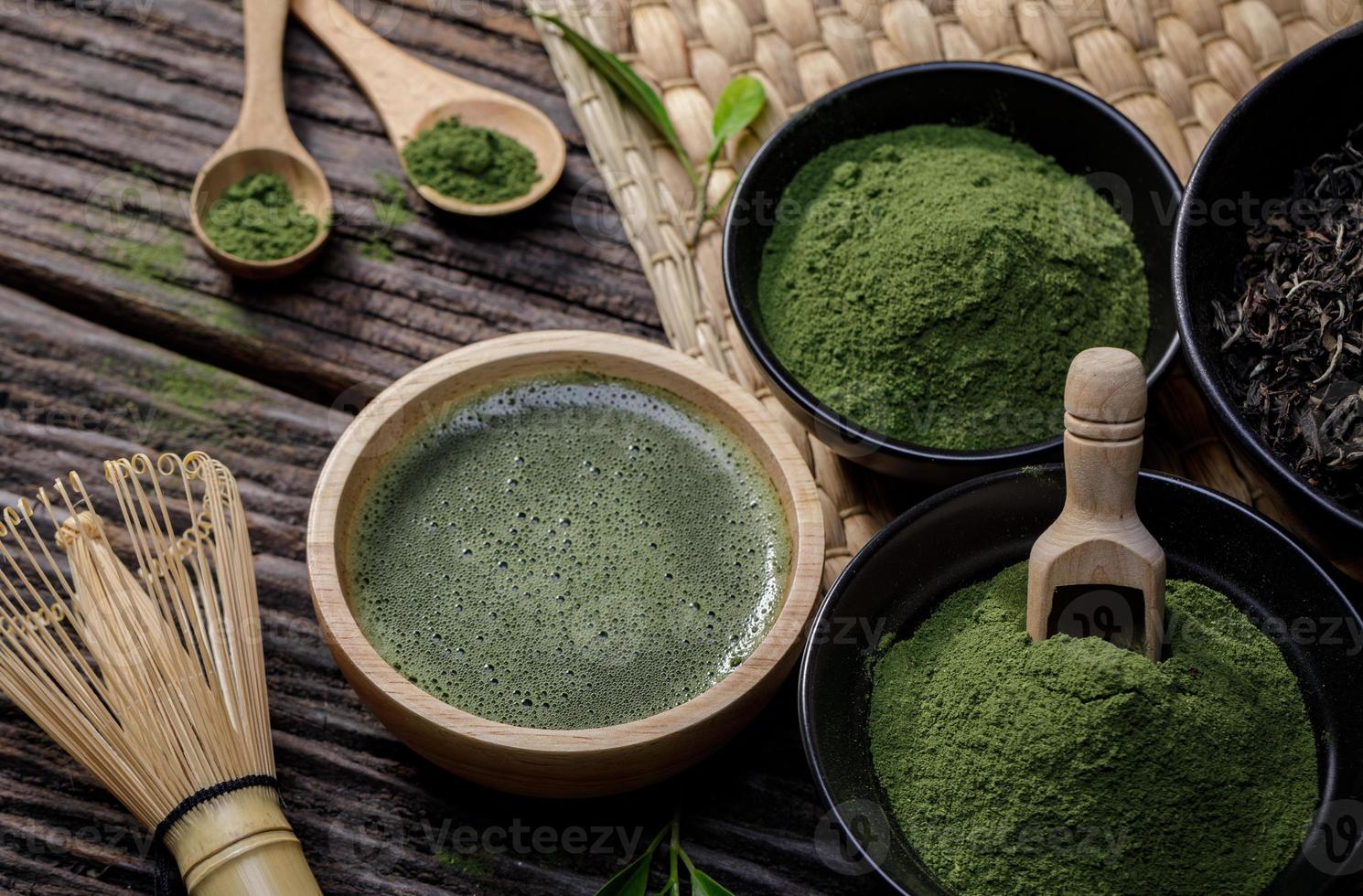 Japans biologisch matcha groen thee poeder in kom met draad vliegenmepper en groen thee blad Aan houten achtergrond, biologisch Product van de natuur voor gezond met traditioneel stijl foto