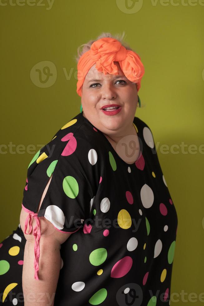 portret van plus grootte jong dame glimlachen handen houdt zand klok geïsoleerd Aan roze kleur achtergrond. foto