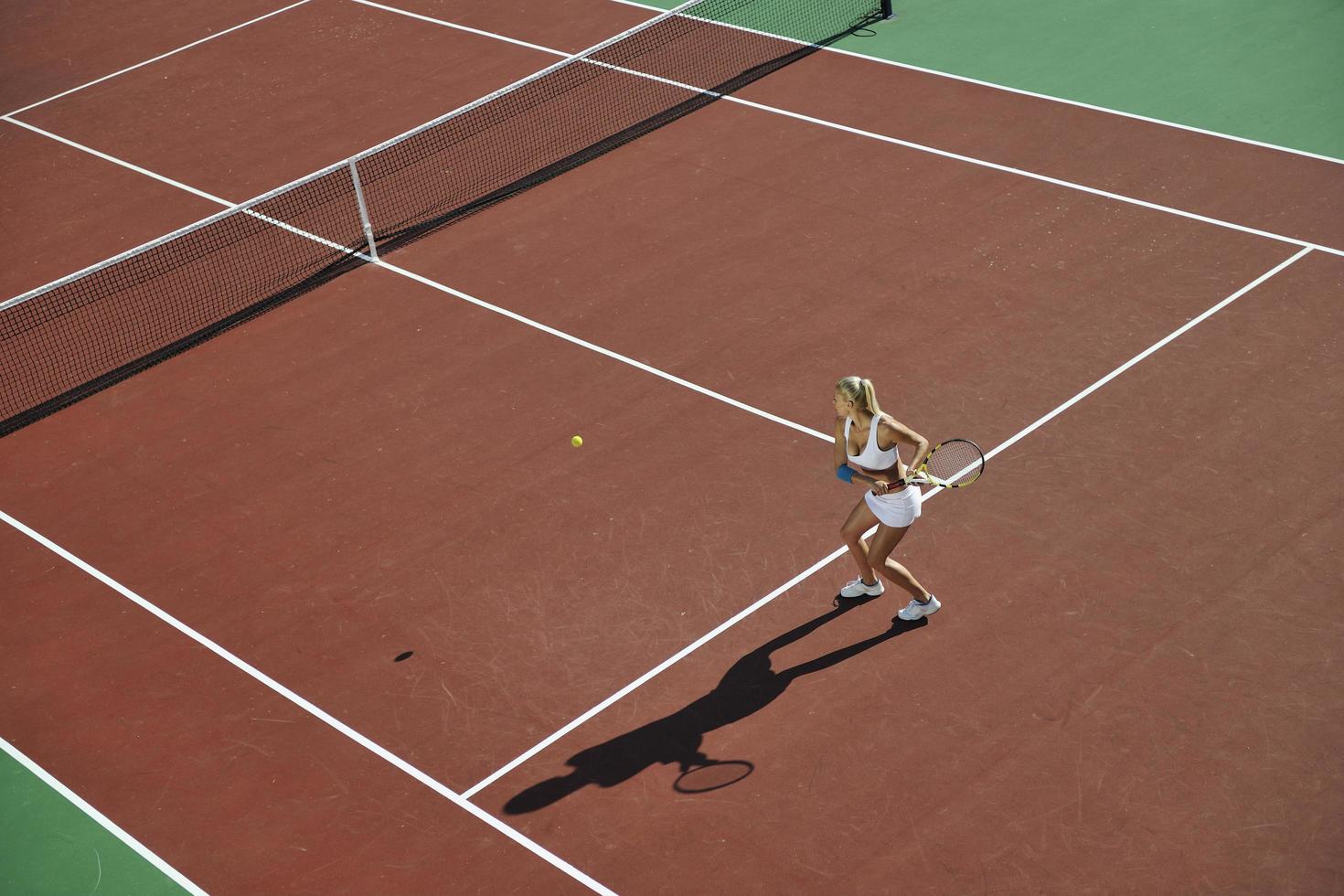 jonge vrouw speelt tennis foto